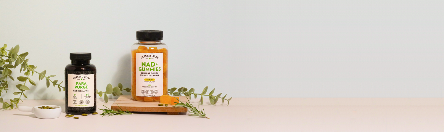 Two supplement bottles on a wooden block with greenery on a light background